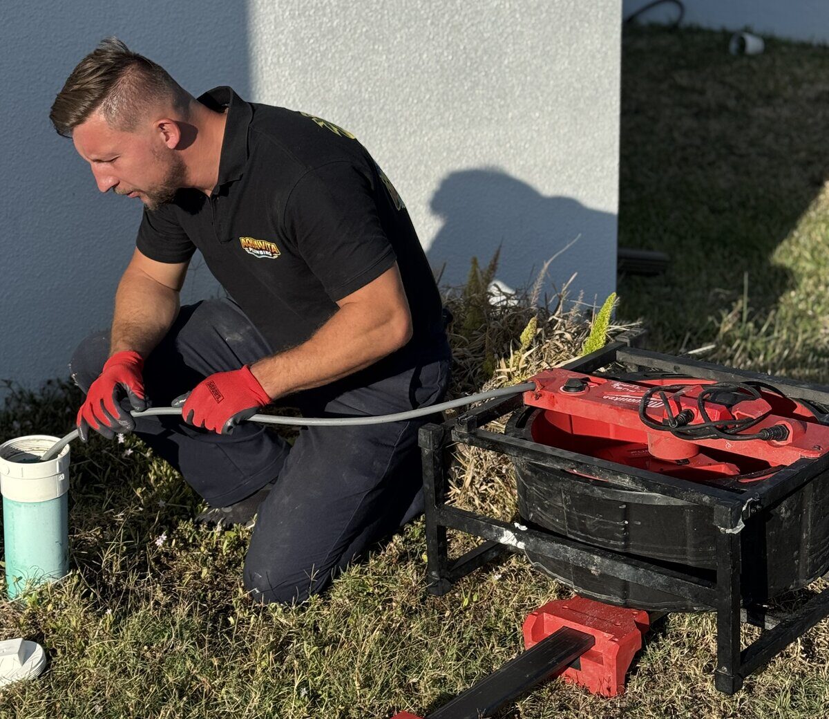Oskar Huber, owner of Aqua Vita Plumbing, clearing a drain line with a Milwaukee drain machine at a Cape Coral home